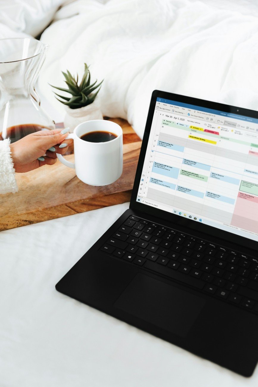 Person organizing tasks on Notion and Google Sheets while sipping coffee, symbolizing productivity and balance.